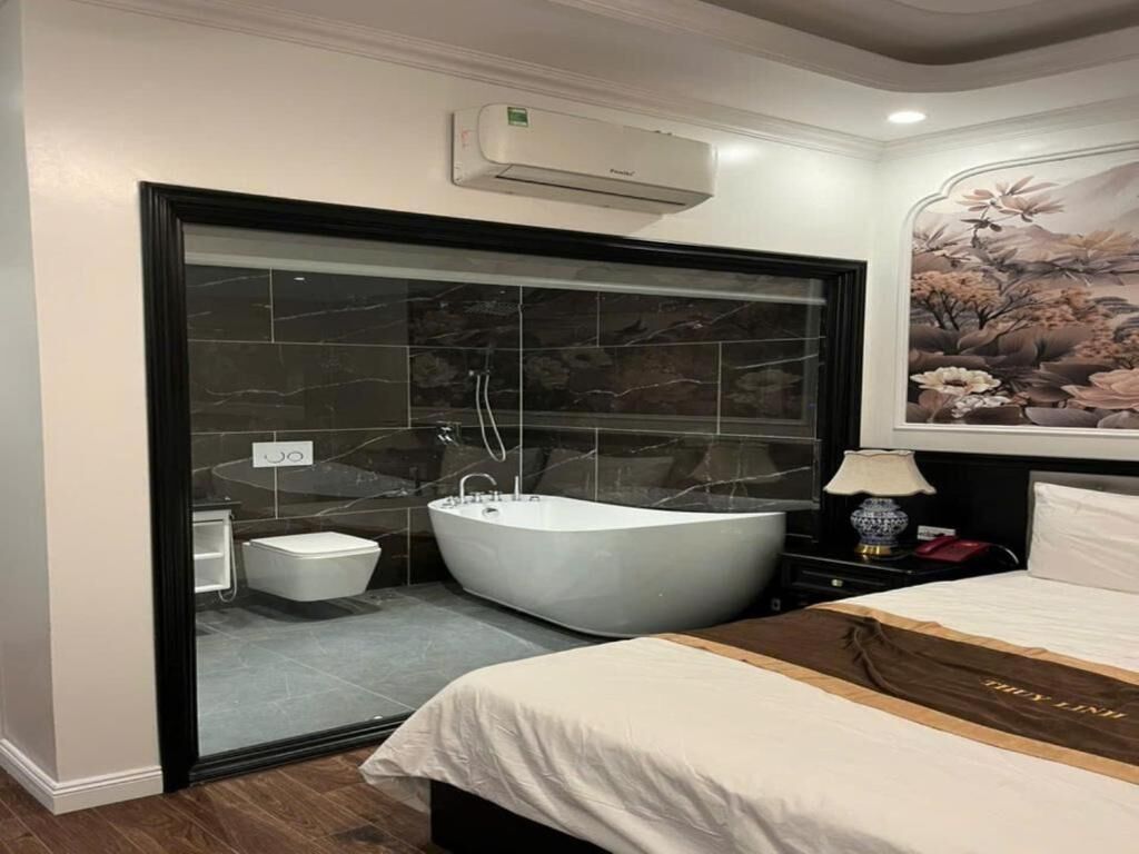 A modern bathroom with a freestanding bathtub, a glass shower enclosure, and a marble-tiled wall.