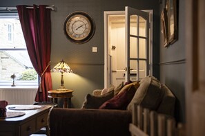 A room with a bed, a lamp, a clock, and a window with curtains. - Boar Edge Cottage, Richmond, Yorkshire Dales (Richmond)