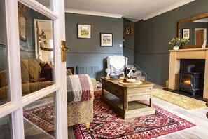 A living room with a sofa, a wooden coffee table, a fireplace, and a patterned rug. - Boar Edge Cottage, Richmond, Yorkshire Dales (Richmond)
