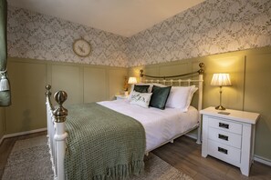 A bedroom with a bed, nightstands, a clock, and a green throw blanket. - Boar Edge Cottage, Richmond, Yorkshire Dales (Richmond)