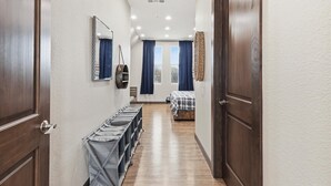 Un couloir comprenant un lit, une armoire et un miroir.