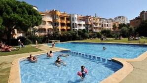 Una piscina rodeada de edificios de varios pisos con balcones.