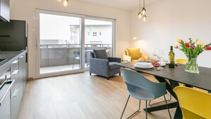A modern kitchen with a dining area, a balcony, and a view of the city. - Stylish holiday apartment in Jenbach centre (Jenbach)