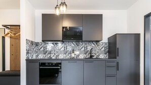 Eine moderne Küche mit grauen Schränken, einer gemusterten Spritzschutzwand und einem eingebauten Ofen.
