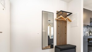 Ein modernes Interieur mit einer Wandpaneelaus Holz, einer schwarzen Bank und einer Küchenzeile mit einem gemusterten Spritzschutz.