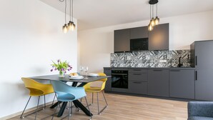 Een moderne keuken met een magnetron, oven en een betegelde achterwand.