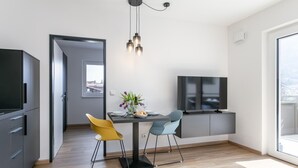 Una cocina moderna con comedor, televisor y un amplio ventanal.