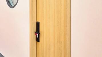 A wooden door with a digital lock and a number plate indicating room 102.