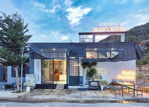 A two-story building with a sign reading 'Homestay Moon's House.'