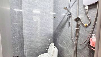 Un baño con ducha, inodoro y secamanos.