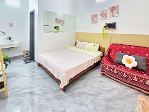 A bedroom with a bed, a sofa, a bedside table, a mirror, and a wall-mounted shelf. - Moon's House (Phu Cat)