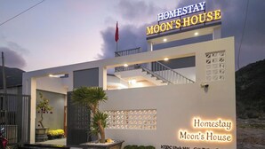 Un edificio moderno con un cartello che riporta la scritta 'Homestay Moon's House'.