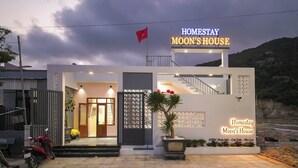 Un edificio a due piani con un cartello che riporta 'Homestay Moon's House'.