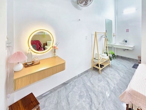 A bathroom with a vanity, a mirror, a hanging rack, and a sink. - Moon's House (Phu Cat)