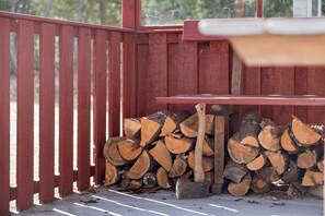 A red wooden fence, a stack of firewood, and a table. - Experience the calm home near sea and forest (Hadsund)