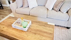 A living room with a beige sofa, a wooden coffee table, and a patterned rug. - Nice Modern Vintage House near Sky Harbor Airport (Phoenix)