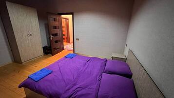 Un dormitorio con una cama, un armario y una puerta que da a otra habitación.