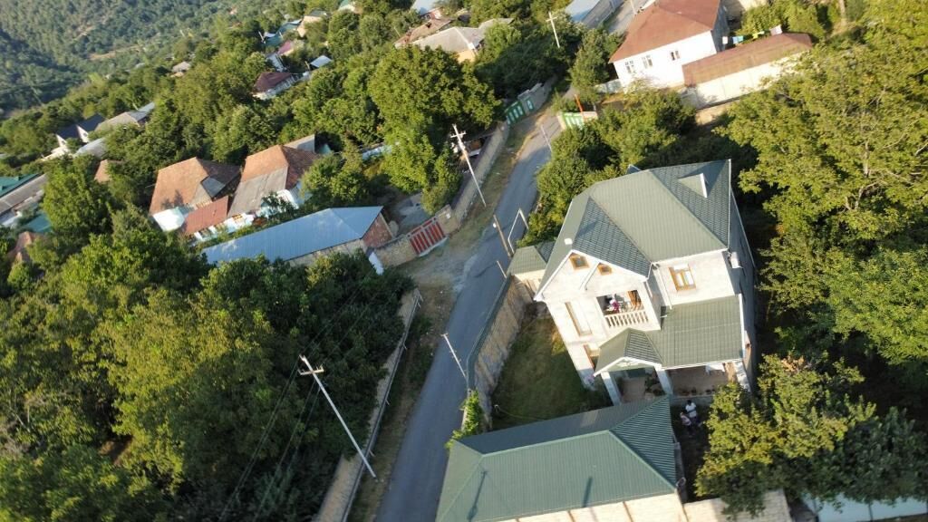 Vue aérienne d’un quartier résidentiel avec des maisons, une église et une route.