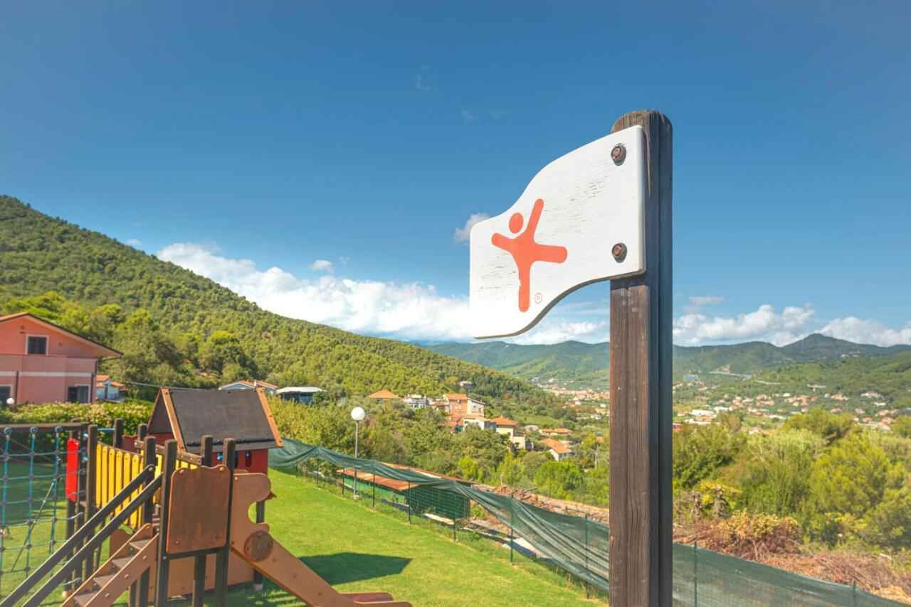 Ein Spielplatz mit einer Kletteranlage und einem Wegweiser mit einem Symbol.