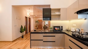 A modern kitchen with a central island, built-in appliances, and a wooden partition. - Staymaster Terra Nusa 4BR Villa (Colvale)