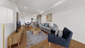Ein modernes Wohnzimmer mit einer Couch, einem Couchtisch und einem Essbereich mit Stühlen und einem Tisch.