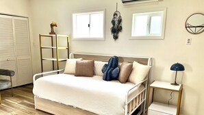 A neatly arranged bedroom with a bed, bedside table, and a wardrobe.