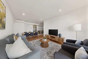 A modern living room with a sofa, coffee table, and TV.