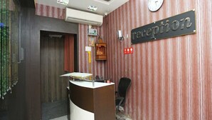 Ett entréområde med en receptionsdisk, en klocka och en skylt med texten ”reception”.