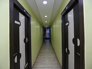 Un couloir avec des portes numérotées 207 et 202, qui donnent accès à des pièces.