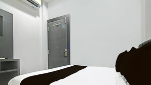 Quarto de hotel com cama, guarda-roupa e porta.