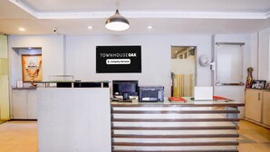 A reception desk with a sign reading 'TOWNHOUSE OAK' and a 'Company-Serviced' label. - Townhouse Oak Ulwe (Panvel)
