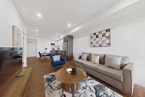 A modern living room with a sofa, coffee table, and dining area.