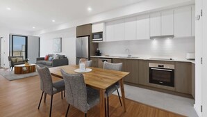 A modern kitchen with a dining area, a built-in oven, and a large window.