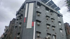 En byggnad med flera våningar, balkonger, luftkonditioneringsanläggningar och en butikslokal på bottenvåningen.