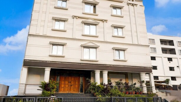 A multi-story building with a symmetrical facade, large windows, and a central entrance with a wooden door.