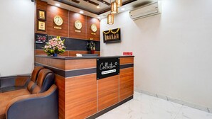 A reception desk with a sign reading 'Collection Company Serviced,' a clock, and a digital display.
