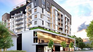 A multi-story building with balconies, a ground-level commercial area, and a modern architectural design.