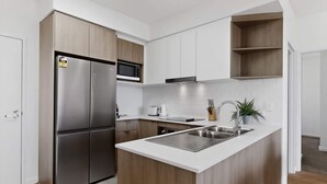 A modern kitchen with a built-in island, stainless steel appliances, and white cabinetry.