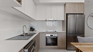 A modern kitchen with a dishwasher, oven, and refrigerator.