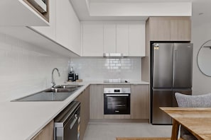 Eine moderne Küche mit Geschirrspüler, Backofen und Kühlschrank.