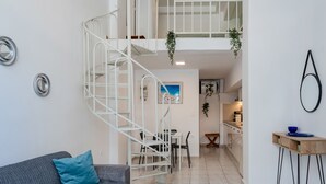 Um interior moderno com escada, área de jantar e cozinha.
