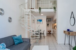 A modern interior with a staircase, a dining area, and a kitchen. - Kalimera Beach Apartment 2 – Town Experience : (Rethymno)