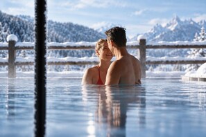A couple in a hot tub with a snowy mountain backdrop. - Hotel AUI (Rio di Pusteria)