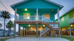 A two-story building with a balcony and a staircase. - Private Pool + Lounge + Mins to Shore & Dining | Beach House | Tickle My Fansea (Port Aransas)