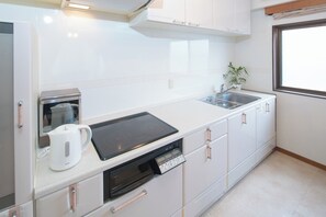 Kylskåp, mikrovågsugn, spishäll och grytor/köksredskap