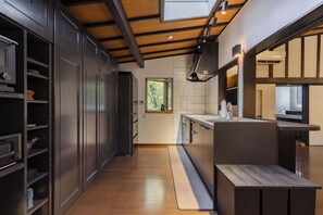 Una cocina moderna con armarios oscuros, encimera de madera y un tragaluz.