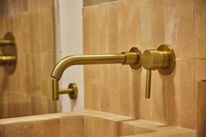 A bathroom with a gold-colored faucet and wall-mounted towel rack. - C diz Deluxe Apartment by Livework (Cádiz)