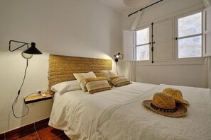 A bedroom with a bed, bedside lamps, a window, and a woven headboard. - Apartamento Mes n C diz by Livework (Cádiz)
