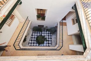 A courtyard with a checkered floor, a small window with plants, and a staircase. - Apartamento Mes n C diz by Livework (Cádiz)