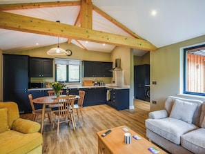 A spacious living area with a dining table, chairs, a sofa, and a coffee table.